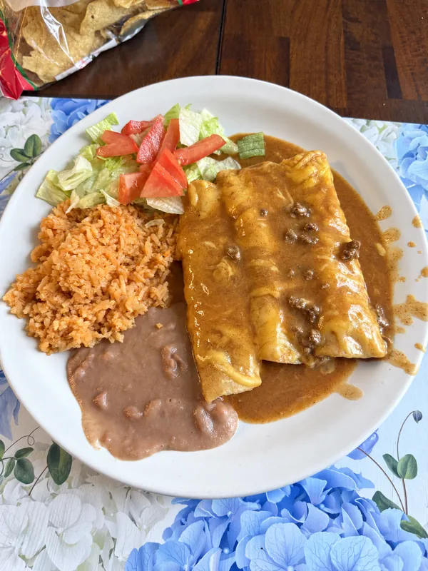 Enchiladas with rice, beans and a side salad prepared by Lino Cantú