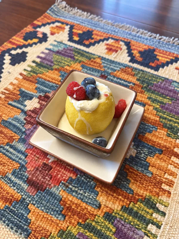 A fruit dessert topped with cream and berries prepared by Lino Cantú